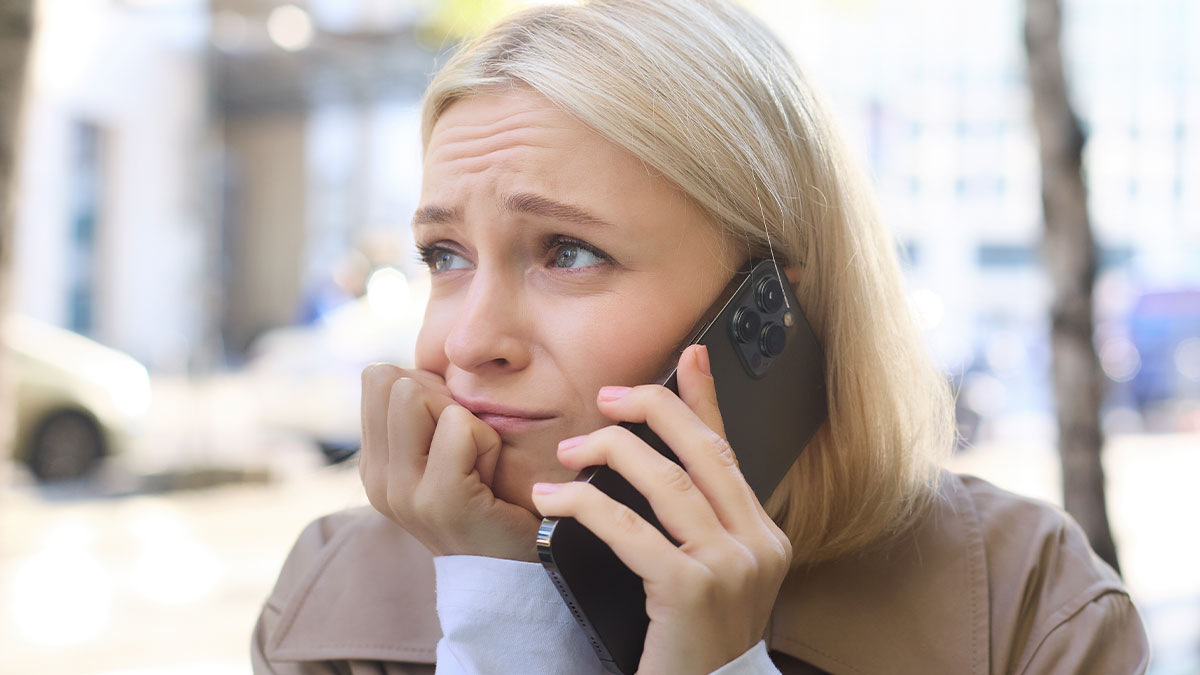 Worried woman on phone upset after younger sister refuses free babysitting on demand for years outdoors