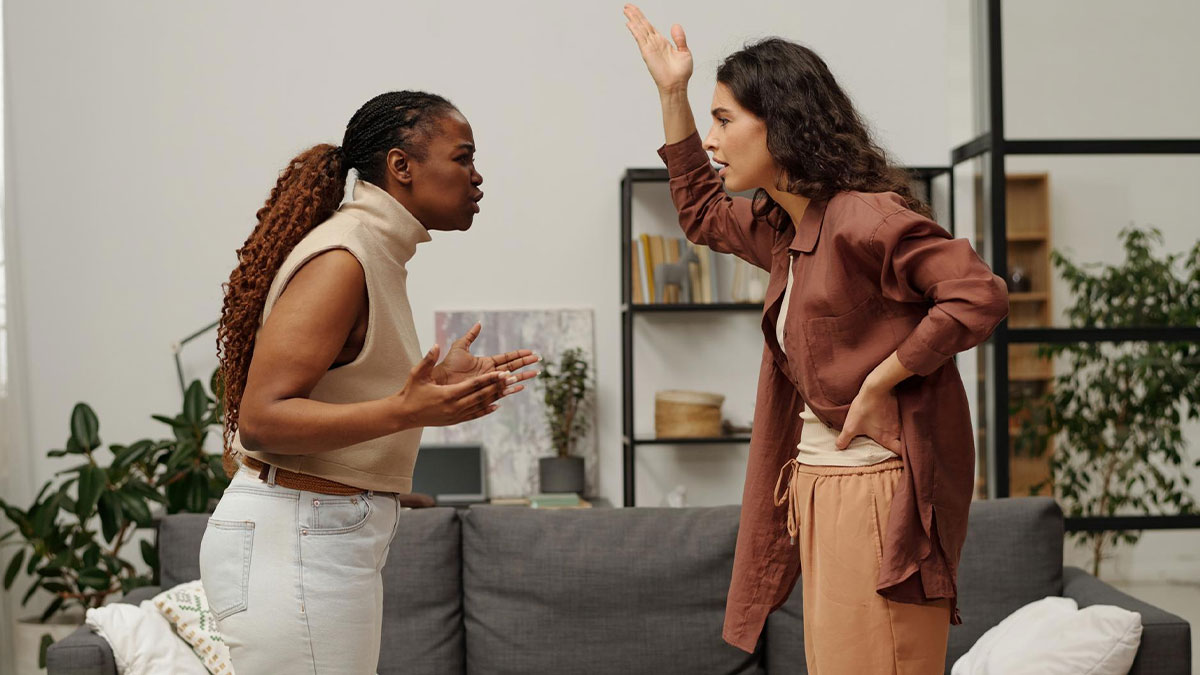 Two women arguing indoors, one stay-at-home mom and her sister-in-law debating about college degrees and achievements.