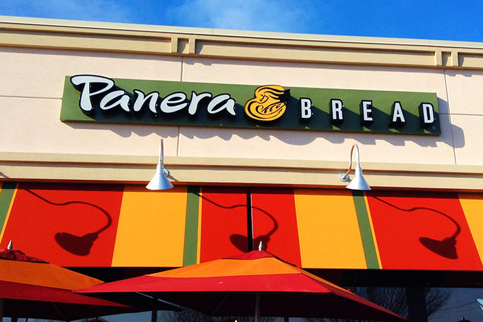 Panera Bread storefront with colorful awnings under a clear blue sky, illustrating lies that affected people's lives.