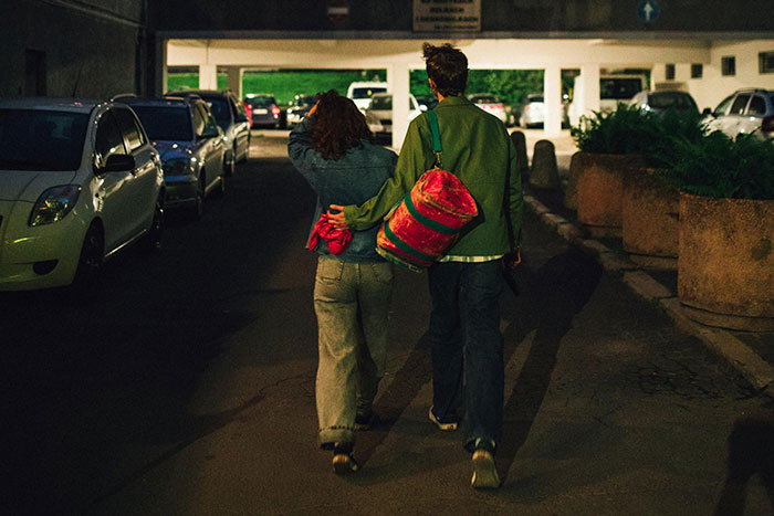 Couple walking arm in arm in a dimly lit parking lot, depicting the impact of lies on people's lives and relationships.