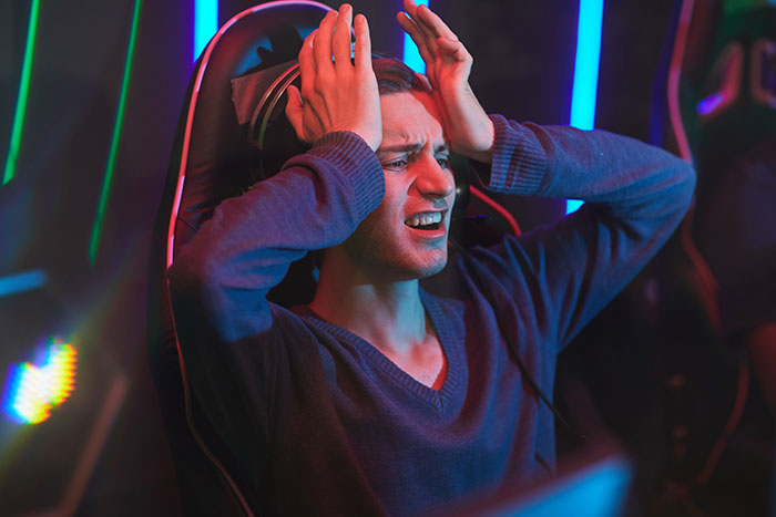Teen sitting in gaming chair with hands on head, frustrated after breaking new chair one day after getting it. Teen sitting in gaming chair with hands on head, frustrated after breaking new chair one day after getting it.