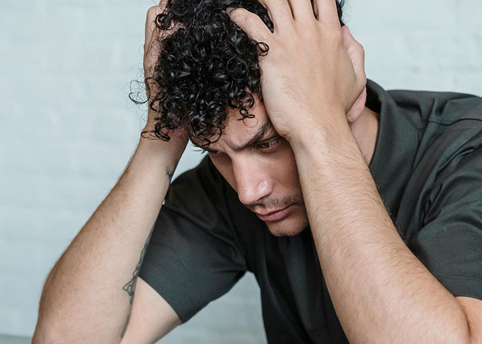 Frustrated man holding head, upset with stalkerish HOA president and facing consequences in court after revealing secrets. Frustrated man holding head, upset with stalkerish HOA president and facing consequences in court after revealing secrets.