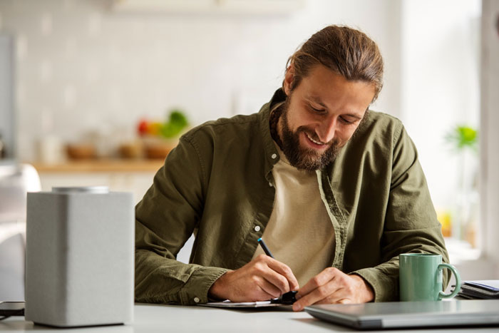 Man with beard writing at desk in bright room, symbolizing stepdad trying to displace kids’ bio dad from their hearts Man with beard writing at desk in bright room, symbolizing stepdad trying to displace kids’ bio dad from their hearts