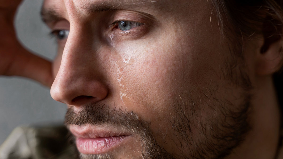 Close-up of a distressed man crying, representing a stepdad upset trying to displace kidsu2019 bio dad from their hearts.