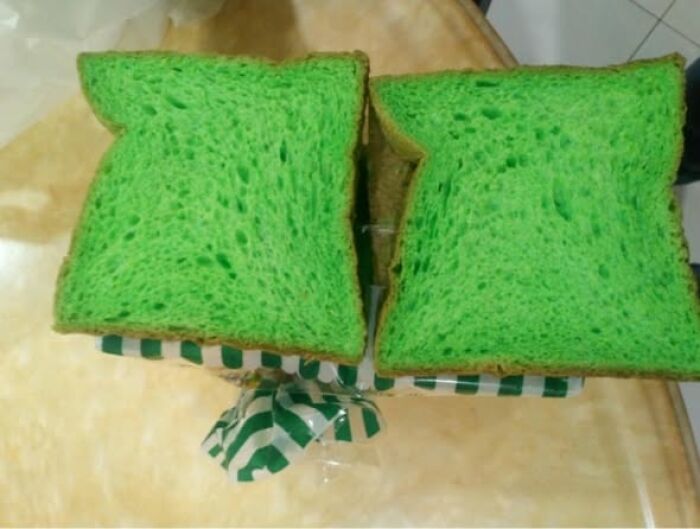 Two slices of bright green bread on a kitchen counter, showing strange and unusual food appearance.
