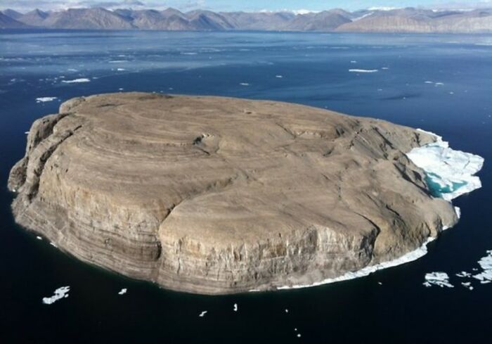 A strange flat-topped island surrounded by icy waters, illustrating unusual facts and stories about our world.
