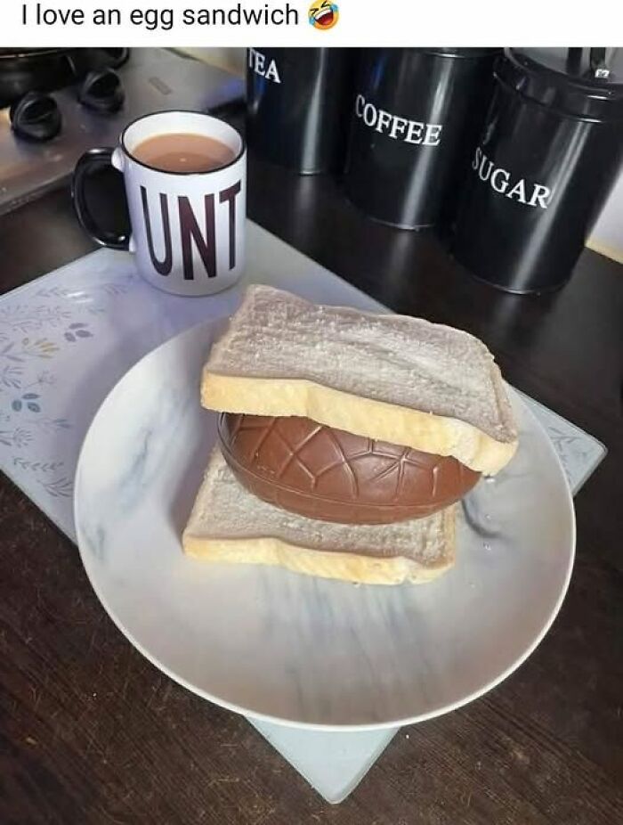 Mug with bold letters and a sandwich made of white bread and a chocolate egg on a plate, funny food meme for stupid people.