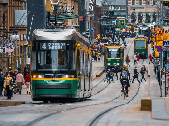 Busy urban street with trams and pedestrians illustrating positive stereotypes about various countries and city life.