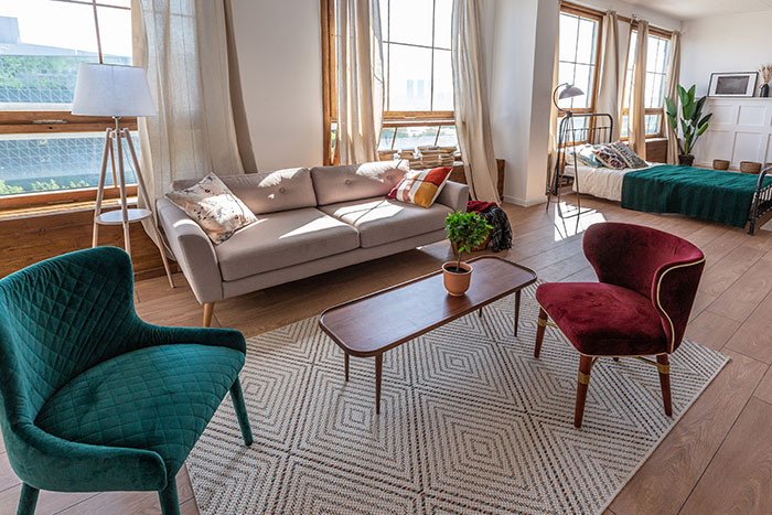 Modern living room with colorful armchairs, sofa, and large windows, illustrating metal detectors at school concept.
