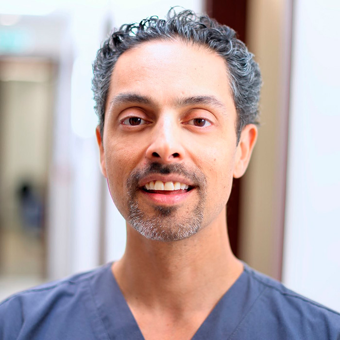Portrait of a smiling man with curly hair, showcasing facial features studied in the golden ratio for beauty analysis.
