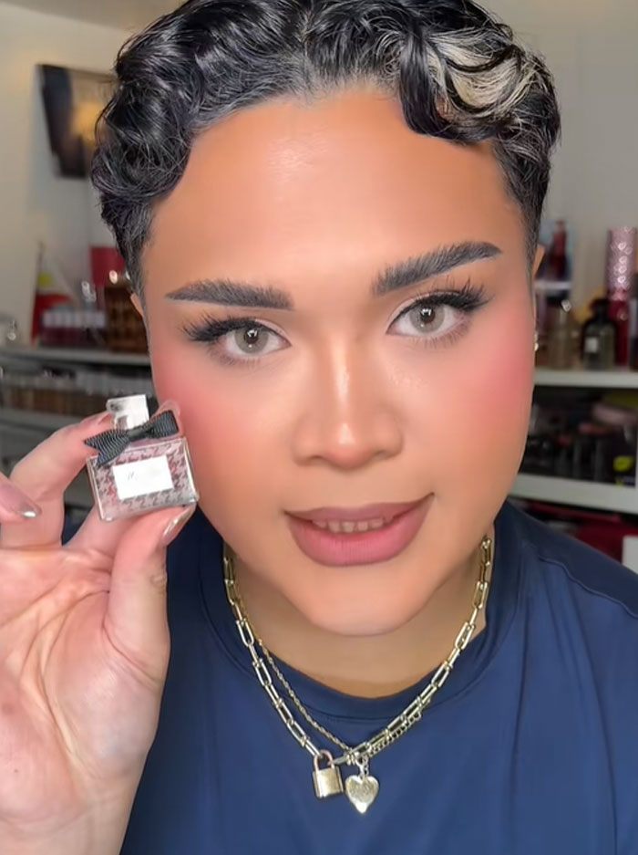 A person holding a small Dior perfume bottle, showcasing a luxury item related to the Dior advent calendar. A person holding a small Dior perfume bottle, showcasing a luxury item related to the Dior advent calendar.