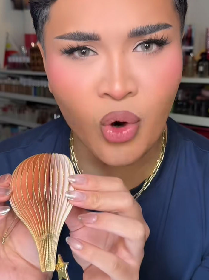 Person with manicured nails holding a decorative item while discussing Dior advent calendar and its $1,000 price. Person with manicured nails holding a decorative item while discussing Dior advent calendar and its $1,000 price.