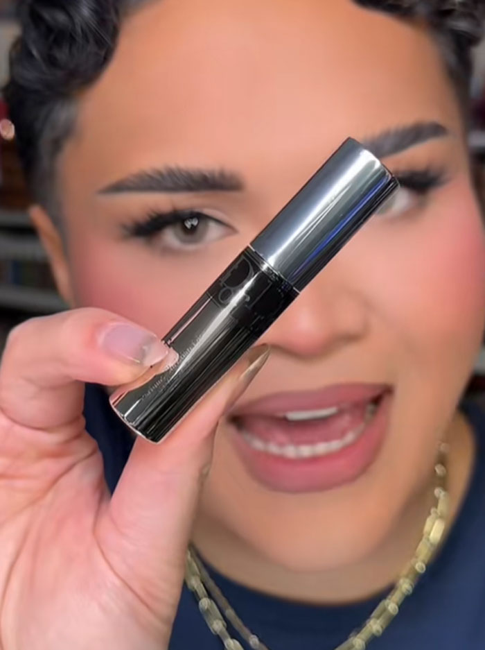 Person holding a Dior product close to the camera, highlighting the luxury advent calendar item in focus. Person holding a Dior product close to the camera, highlighting the luxury advent calendar item in focus.