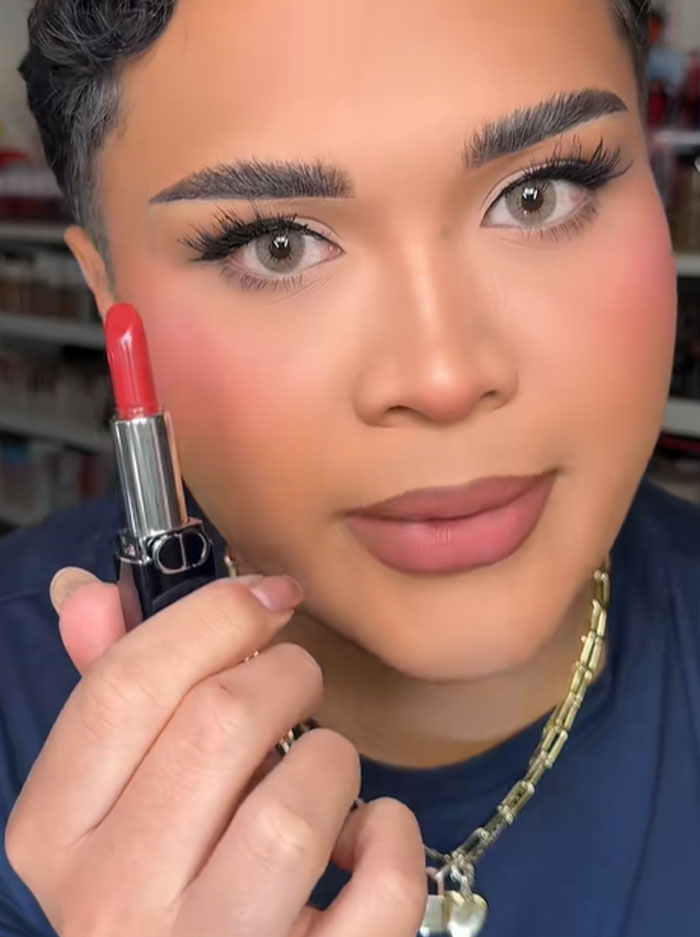 Person holding Dior lipstick close to face, showcasing luxury makeup in a beauty and Dior advent calendar context. Person holding Dior lipstick close to face, showcasing luxury makeup in a beauty and Dior advent calendar context.