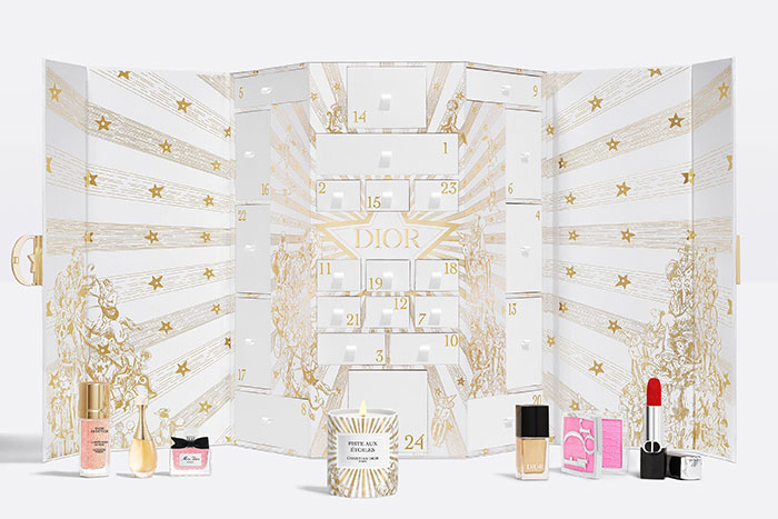 Dior luxury advent calendar with beauty products and candle, featuring gold star design and numbered compartments. Dior luxury advent calendar with beauty products and candle, featuring gold star design and numbered compartments.