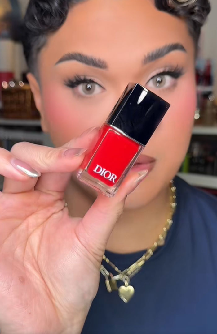 Person holding a red Dior nail polish bottle, highlighting luxury beauty items from a Dior advent calendar. Person holding a red Dior nail polish bottle, highlighting luxury beauty items from a Dior advent calendar.