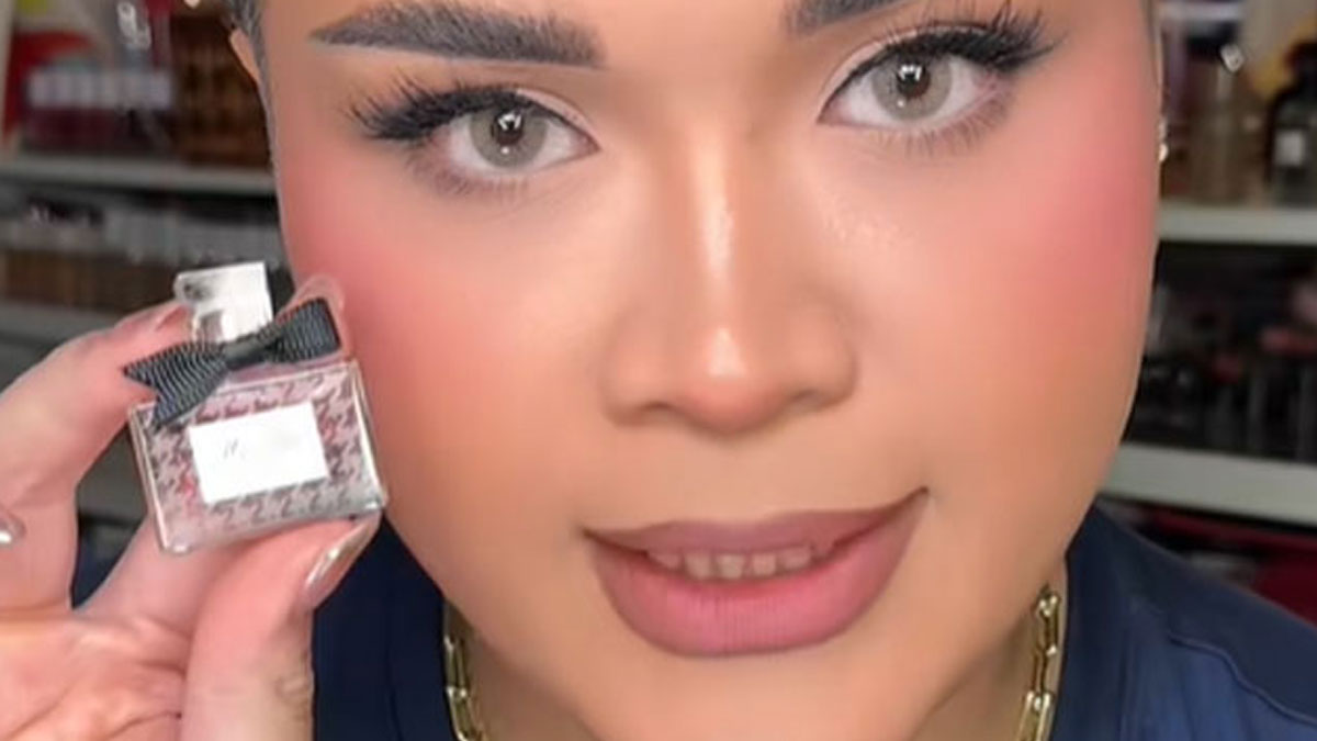 Close-up of a person holding a tiny Dior perfume bottle from the high-priced advent calendar, highlighting luxury beauty products.