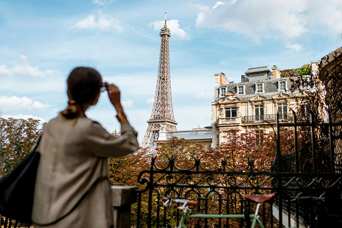 Solo female traveler looking at the Eiffel Tower in Paris, illustrating places solo female travelers do not recommend.
