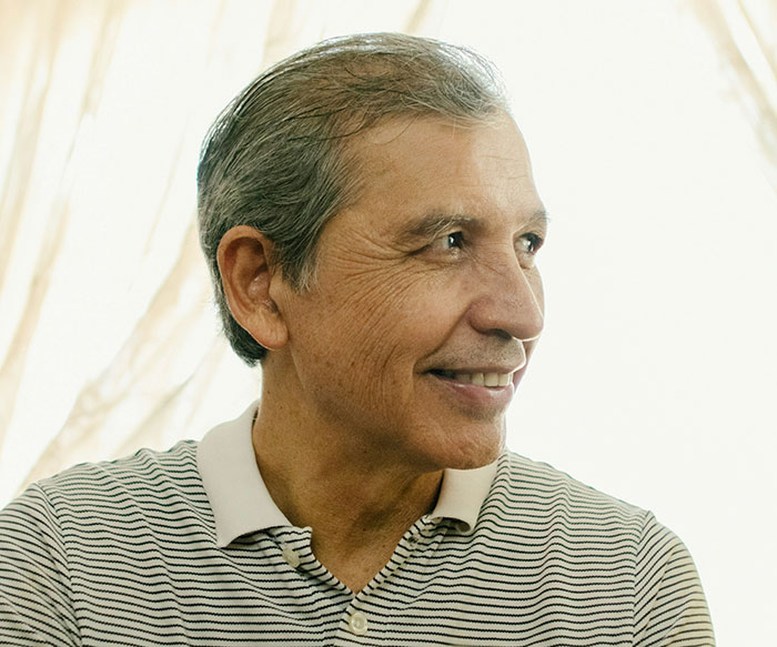 Older man in a striped polo shirt looking sideways, illustrating a concept about solo female travelers and safety concerns.