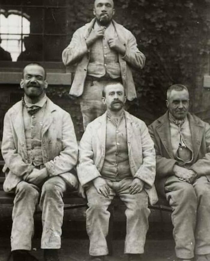 Group portrait of five men in Victorian-Edwardian pictures, wearing period clothing with serious expressions outdoors.