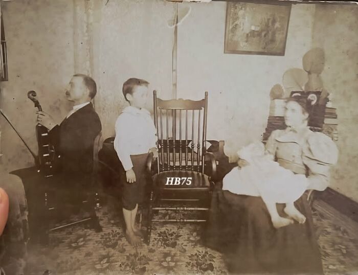 Victorian-Edwardian pictures of a family in vintage clothing with a man playing violin and a woman holding a child indoors.