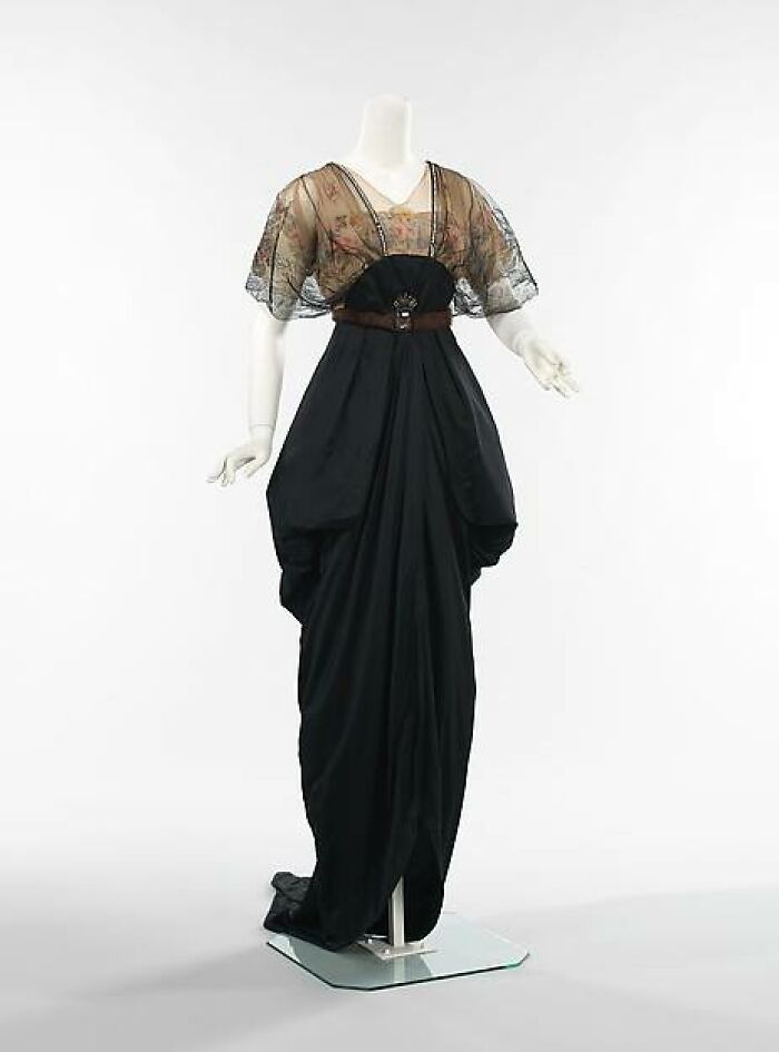 Victorian-Edwardian pictures of a black high-waisted gown with sheer floral sleeves displayed on a mannequin.