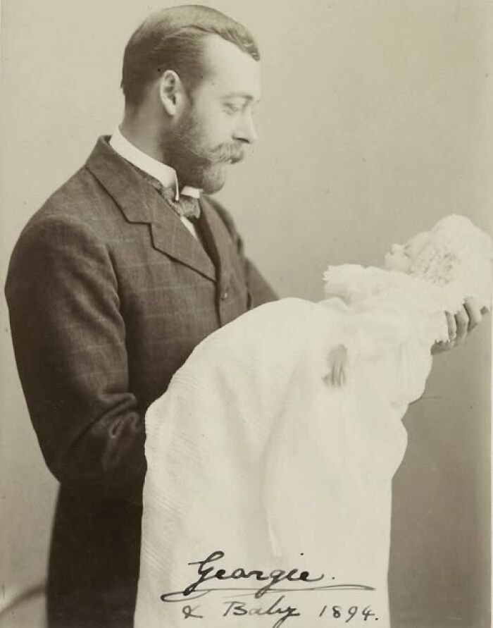 Victorian Edwardian picture of a man in a suit holding a baby dressed in a long white gown and bonnet, 1894.