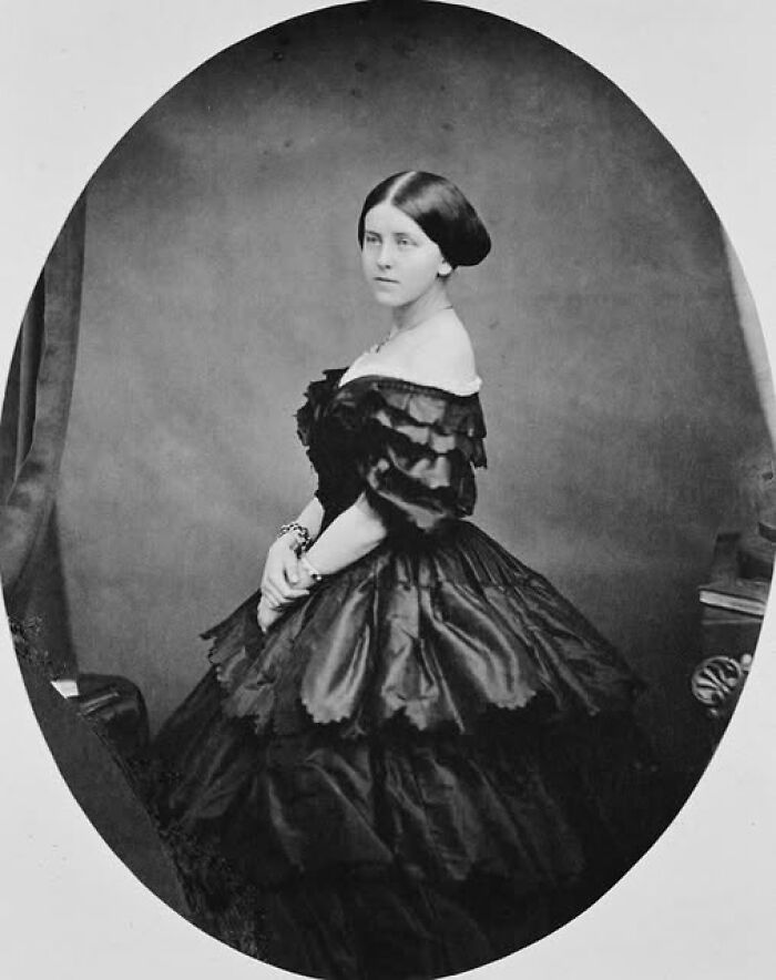 Victorian-Edwardian pictures of a woman posing in an elegant dark ruffled gown against a plain backdrop.