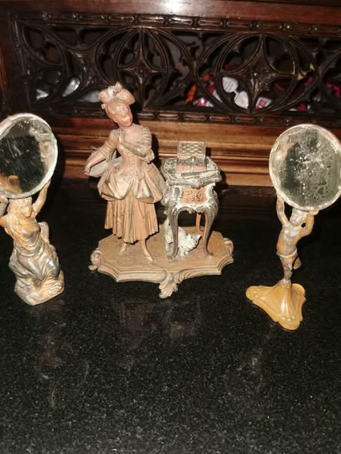 Antique Victorian-Edwardian pictures featuring a detailed figurine of a woman with mirrors and ornate furniture on a dark surface.