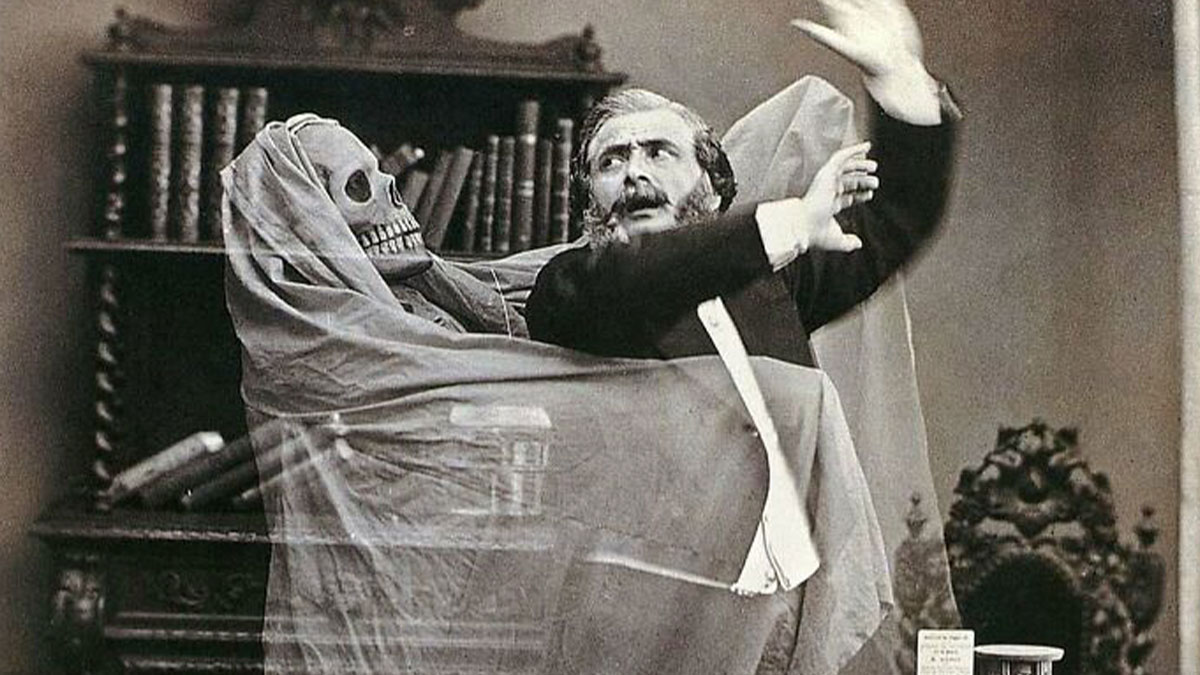 Victorian era weird photo shows a man startled by a skeleton figure draped in cloth in a vintage room setting.