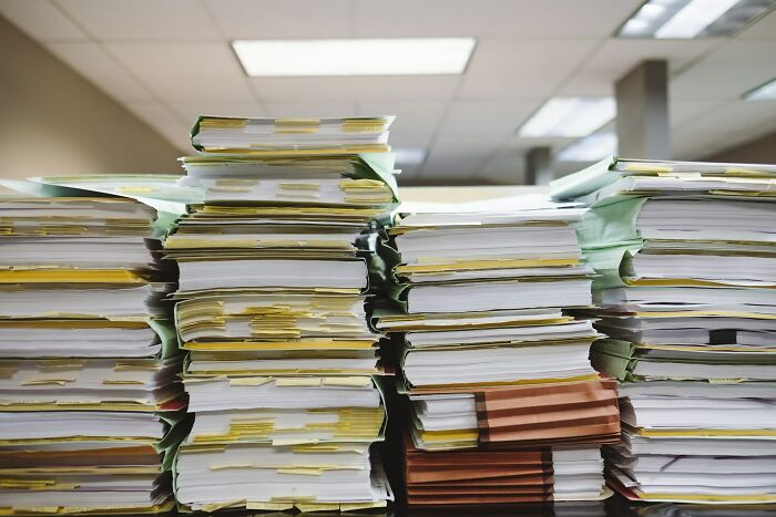 Stacks of disorganized documents and files piled high, illustrating bizarre moments that challenge sanity and order.