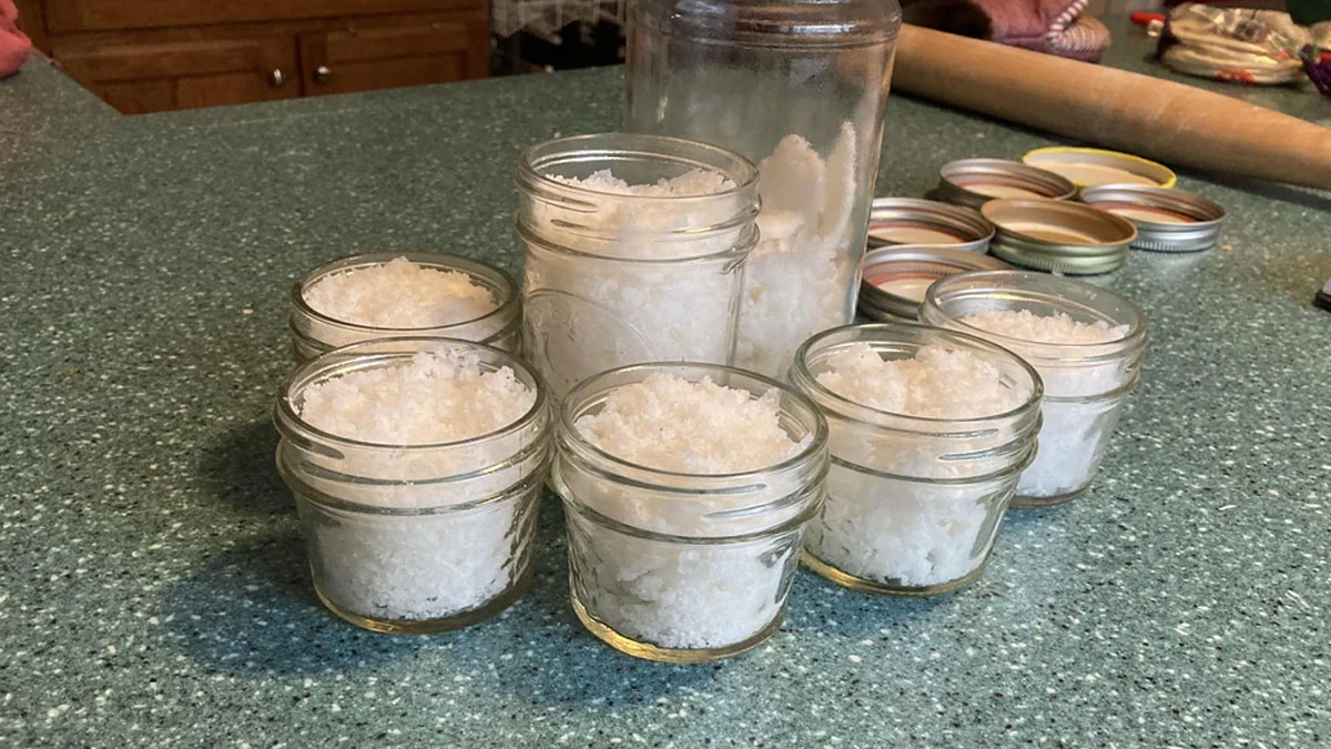 Several small glass jars filled with coarse salt on a kitchen countertop, an interesting pic answering questions.