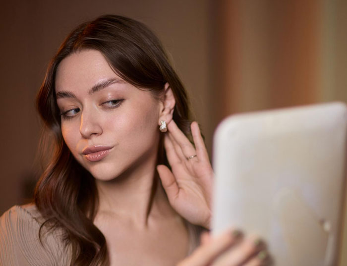 Young Etsy artist promoting her handmade earrings in a selfie, showcasing bracelets and coupons at a family event. Young Etsy artist promoting her handmade earrings in a selfie, showcasing bracelets and coupons at a family event.