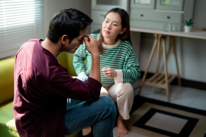 Young man looking distressed while talking to a woman offering support about insensitive things said to people with cancer.