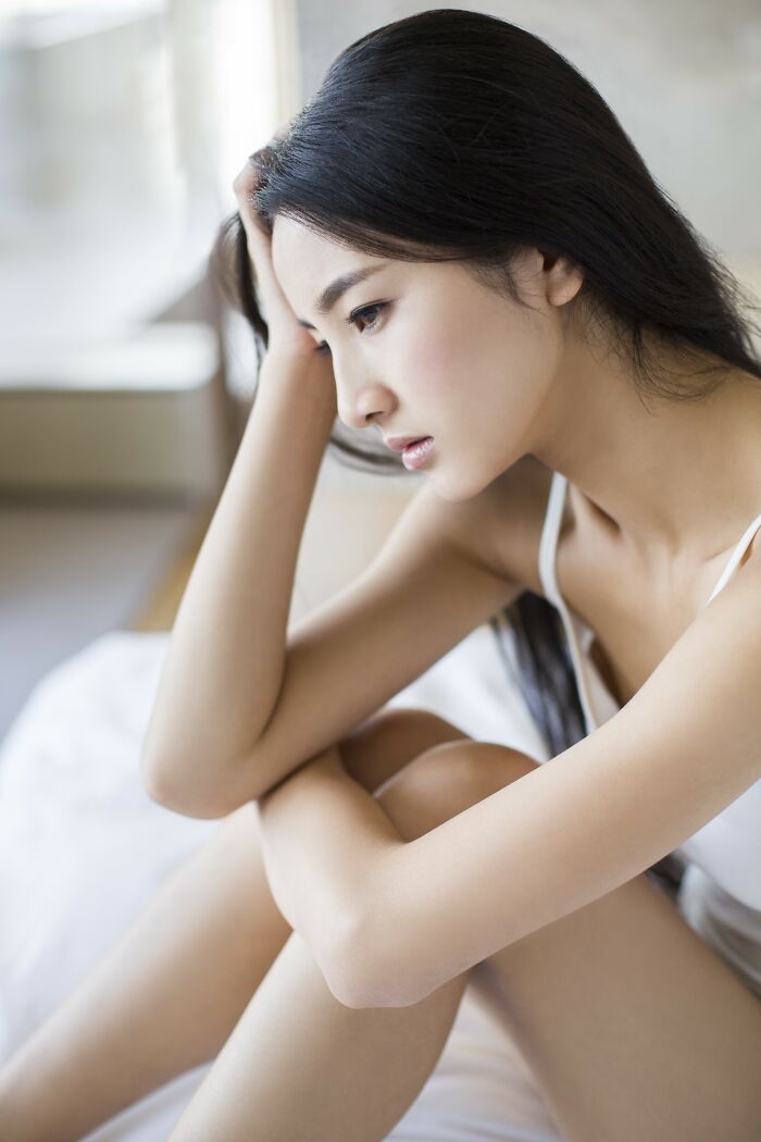 Young woman sitting alone looking sad and distressed, reflecting the pain of insensitive things said to people struggling.