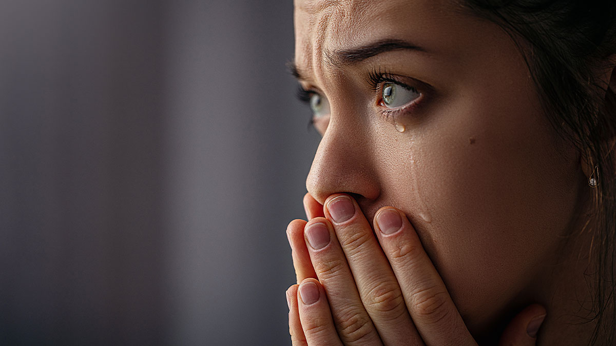 Close-up of a woman crying with tears, reflecting the reality check about being a stay-at-home momu2019s challenges.