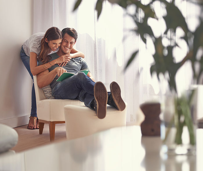Couple sharing a joyful moment at home, highlighting a guy secretly giving his sister a key to his girlfriend’s house.