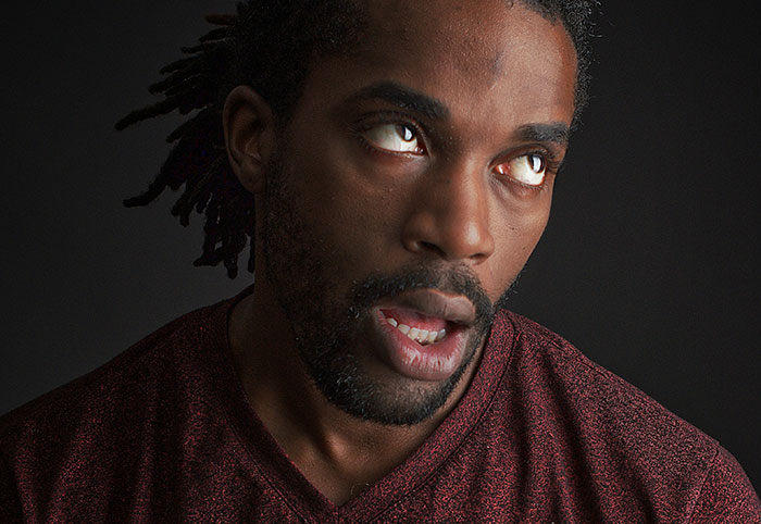 Man with dreadlocks and beard showing expression of frustration and exhaustion in a dark setting related to woman child traits