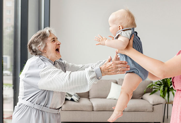 Elderly MIL reaching out happily to a baby grandchild while other kids are treated like burdens at home. Elderly MIL reaching out happily to a baby grandchild while other kids are treated like burdens at home.