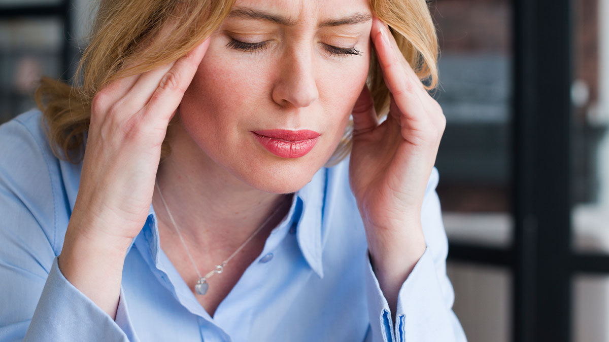 Woman looking stressed and frustrated, holding her head with both hands, illustrating chaos in a relationship.