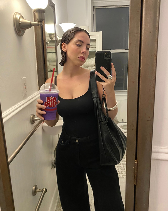 Woman taking mirror selfie holding a purple Big Gulp drink, showing a feminist tattoo rule sparking internet debate. Woman taking mirror selfie holding a purple Big Gulp drink, showing a feminist tattoo rule sparking internet debate.
