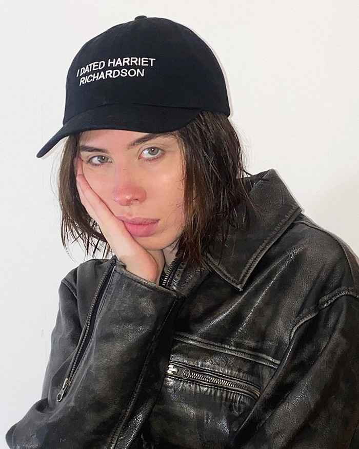 Young woman wearing a black cap and leather jacket highlighting a feminist tattoo rule, sparking creepy and cringe debates online.