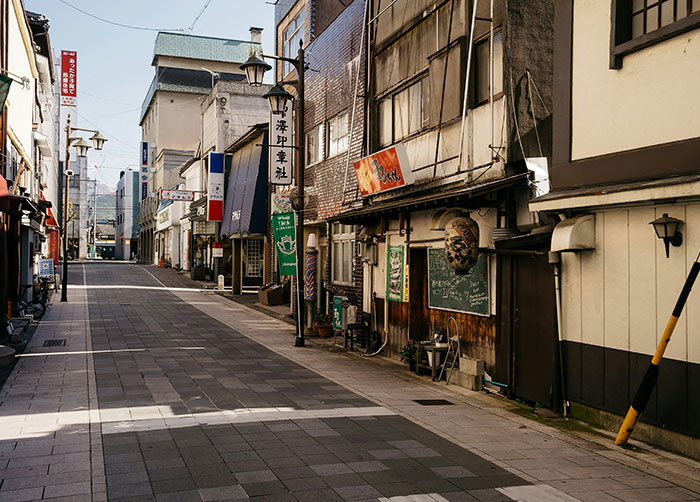 Quiet empty street in Japan showing buildings where people might have the worst night’s sleep because of the place they were in