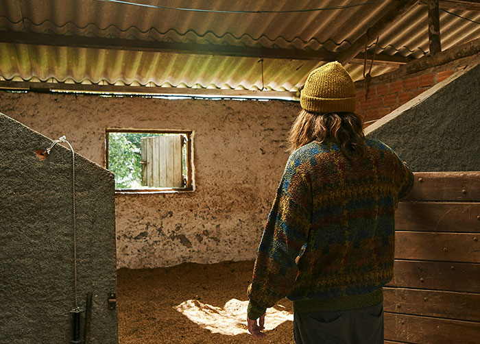 Person in a rustic, poorly lit room with rough walls, illustrating worst night’s sleep because of the place they were in.