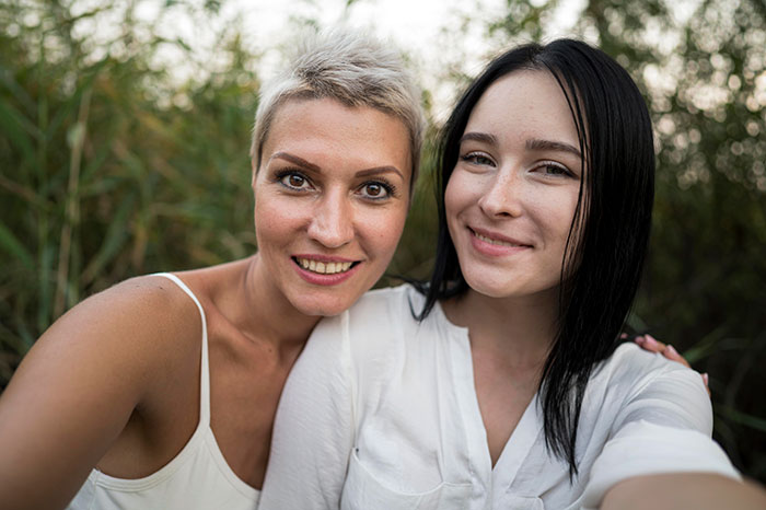 Two women smiling outside, symbolizing late half-sis lies and family support with medical bills. Two women smiling outside, symbolizing late half-sis lies and family support with medical bills.