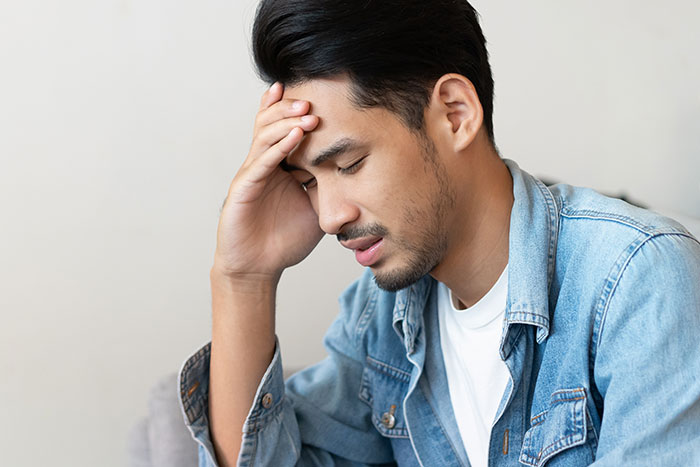 Man in a denim jacket looking distressed, reflecting feelings of hurt and challenges of work-family balance. Man in a denim jacket looking distressed, reflecting feelings of hurt and challenges of work-family balance.