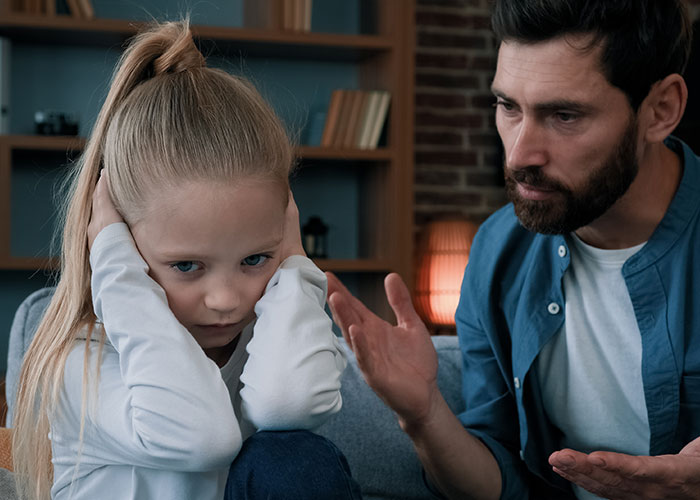 Teen girl upset refusing to babysit step-siblings as dad talks to her, showing tension and family disagreement at home.