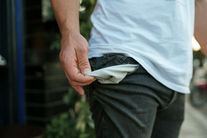 Person showing empty pocket, highlighting surprising habits and secrets people discovered about their partner after moving in.