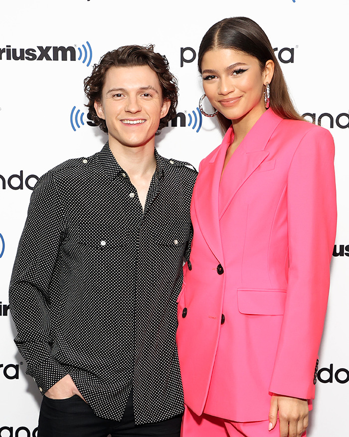 Tom Holland and Zendaya posing together at a media event sparking leaked video and pregnancy rumors online.