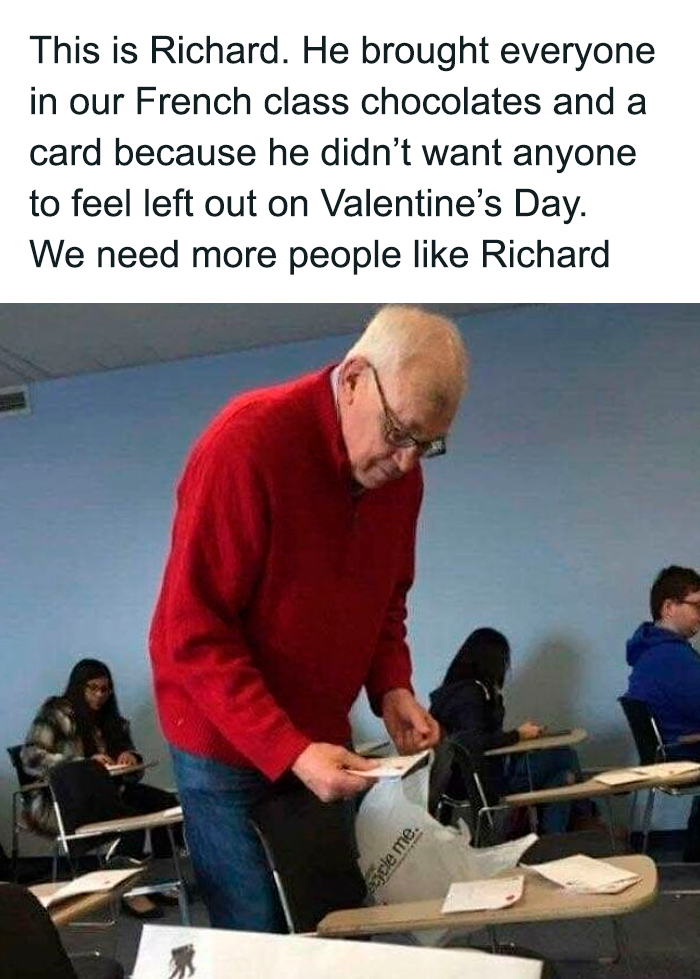 Older man in red sweater handing out chocolates and cards in a classroom, a sweet and wholesome moment to cleanse your feed.